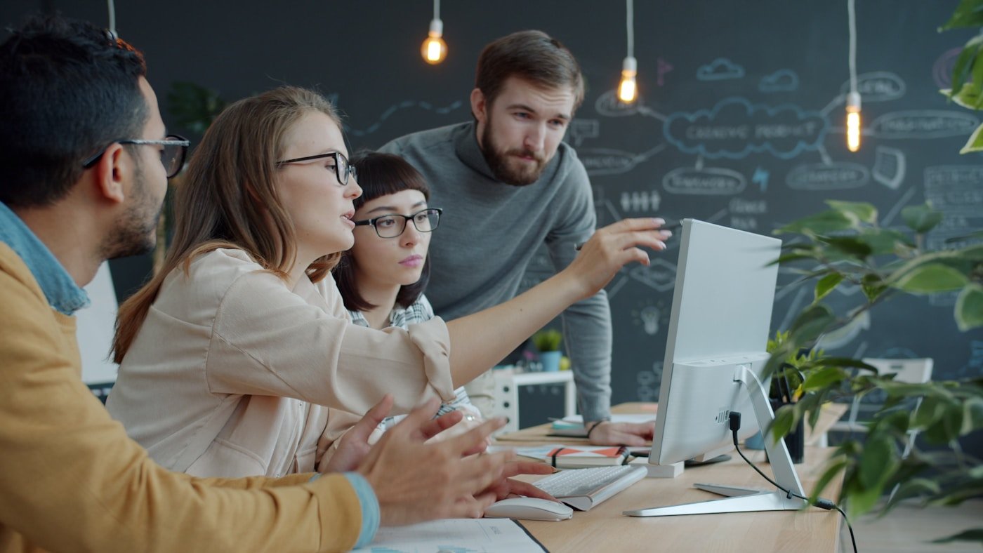 Creative team collaborating around a laptop